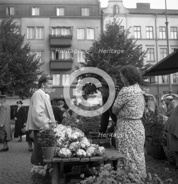 Fruit and vegetable stall selling cauliflowers in the market, Malmö, Sweden, 1947. Creator: Otto Ohm.