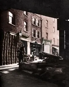 Fruit baskets piled against houses at Borough Market, London, 1926-1927. Artist: Whiffin