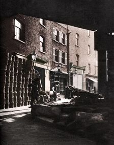 Fruit baskets piled against houses at Borough Market, London, 1926-1927. Artist: Whiffin