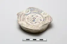 Fragmentary base of a bowl surrounded by wave design, Saljuq period, early 13th century. Creator: Unknown