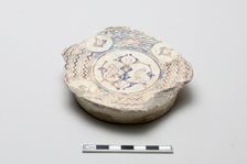 Fragmentary base of a bowl surrounded by wave design, Saljuq period, early 13th century. Creator: Unknown