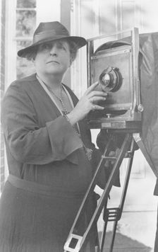 Frances Benjamin Johnston, 1864-1952, half length, facing front, adjusting lens..., c1936. Creator: Frances Benjamin Johnston