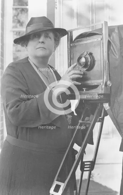 Frances Benjamin Johnston, 1864-1952, half length, facing front, adjusting lens..., c1936. Creator: Frances Benjamin Johnston.