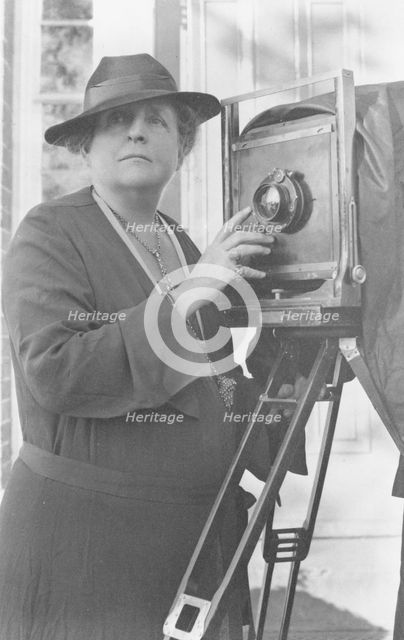 Frances Benjamin Johnston, 1864-1952, half length, facing front, adjusting lens..., c1936. Creator: Frances Benjamin Johnston.