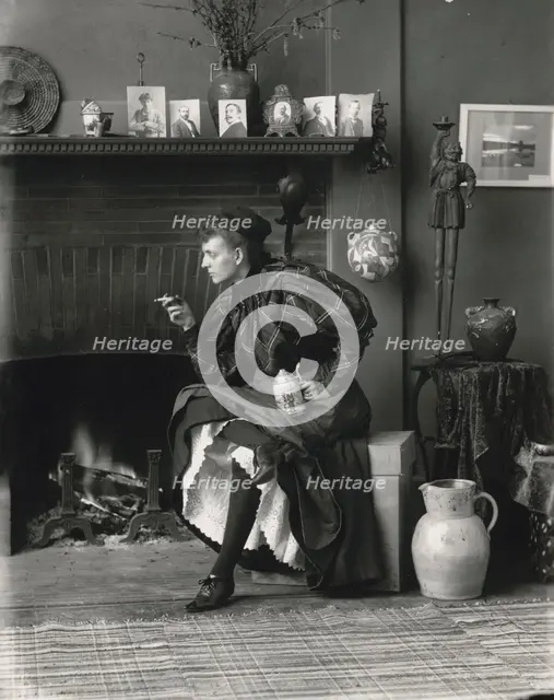 Frances Benjamin Johnston, full-length portrait, seated in front of fireplace, facing left..., 1896. Creator: Frances Benjamin Johnston.