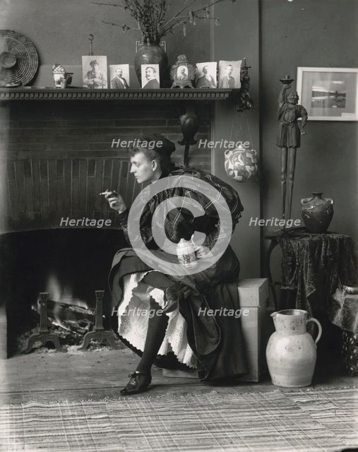 Frances Benjamin Johnston, full-length portrait, seated in front of fireplace, facing left..., 1896. Creator: Frances Benjamin Johnston.