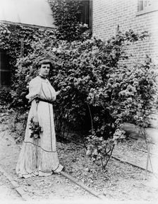 Frances Benjamin Johnston, full-length portrait, standing in her garden..., c1890 - 1910. Creator: Unknown