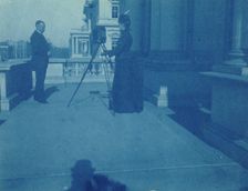 Frances Benjamin Johnston on a balcony of the State, War and Navy Building with a tripod..., 1888. Creator: Frances Benjamin Johnston