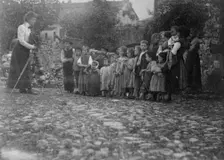 Frances Benjamin Johnston photographing a group of people, mostly children, in Europe, 1900. Creator: Unknown