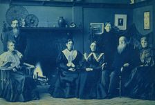 Frances Benjamin Johnston posed with six members of her family, by fireplace, in her Wash..., 1896. Creator: Frances Benjamin Johnston