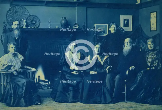 Frances Benjamin Johnston posed with six members of her family, by fireplace, in her Wash..., 1896. Creator: Frances Benjamin Johnston.