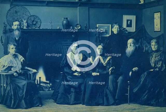 Frances Benjamin Johnston posed with six members of her family, by fireplace, in her Wash..., 1896. Creator: Frances Benjamin Johnston.