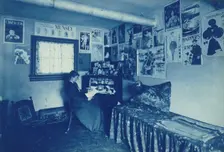 Frances Benjamin Johnston seated at a desk in her studio/office, with adverstising..., c1896. Creator: Frances Benjamin Johnston