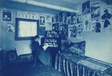 Frances Benjamin Johnston seated at a desk in her studio/office, with adverstising..., c1896. Creator: Frances Benjamin Johnston