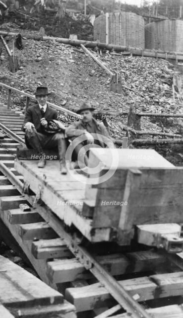 Frank G. Carpenter and man sitting on tracks, between c1900 and 1924. Creator: Unknown.