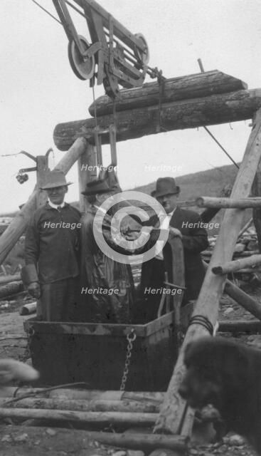 Frank G. Carpenter in middle of bucket at gold mine, between c1900 and 1916. Creator: Unknown.