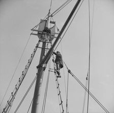 Frank Mineo, owner of the Alden, climbs to the crow's nest..., Gloucester, Massachusetts, 1943. Creator: Gordon Parks