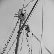 Frank Mineo, owner of the Alden, climbs to the crow's nest..., Gloucester, Massachusetts, 1943. Creator: Gordon Parks