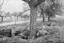 French machine gunners dug in at the edge of a road, under apple trees, 1918