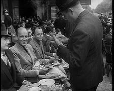 French Police Checking People's Papers Outside a Cafe in Paris, 1940. Creator: British Pathe Ltd
