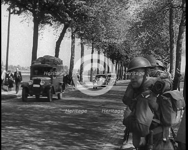 French Refugees Fleeing Town Down Country Roads, British Forces Moving Past Them, 1940. Creator: British Pathe Ltd.