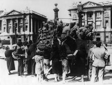 French street sellers offering souvenirs to a truckload of German soldiers, Paris, 27 July 1940