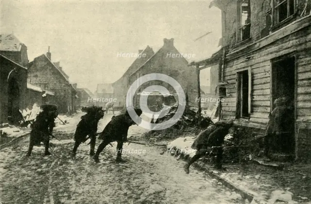 French troops crossing a village street under German fire, First World War, 1914-1915, (c1920). Creator: Unknown.