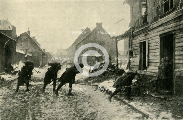 French troops crossing a village street under German fire, First World War, 1914-1915, (c1920). Creator: Unknown.