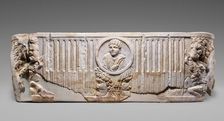 Front of a Sarcophagus with Female Portrait in a Medallion above Two Theatrical Masks...250-275. Creator: Unknown