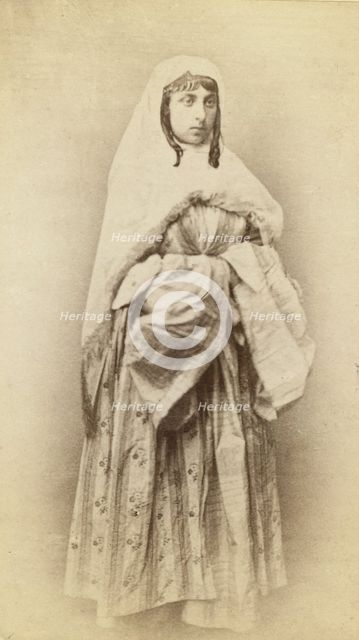 Full-length portrait of a woman, facing slightly right, in traditional dress, between 1870 and 1886. Creator: Unknown.