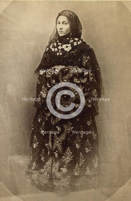 Full-length portrait of a woman in traditional dress, facing slightly left, between 1870 and 1886. Creator: Unknown.