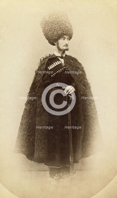 Full-length portrait of a man in cape and sheep skin hat, holding a rifle..., between 1870 and 86. Creator: Unknown.