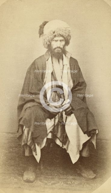 Full-length portrait of man, seated, facing front, between 1870 and 1886. Creator: Unknown.