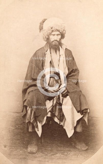 Full-length portrait of man, seated, facing front, between 1870 and 1886. Creator: Unknown.