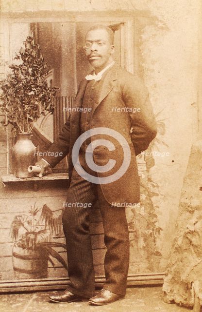 Full-length portrait of man, with studio props, c1880-c1889. Creator: Richmond Photograph Co.