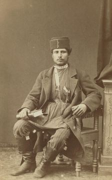 Full-length portrait of Persian man, seated, facing front, between 1870 and 1886. Creator: Unknown