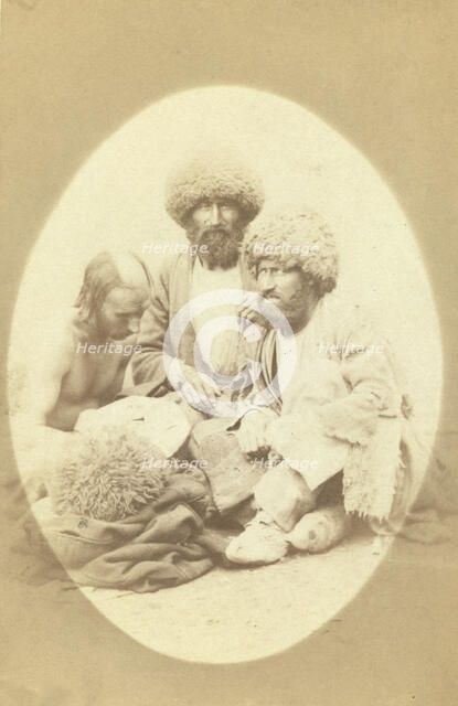 Full-length portrait of three men, seated on ground, facing front, between 1870 and 1886. Creator: Unknown.