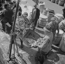 Fulton fish market stevedores unloading and weighing fish in the early morning, New York, 1943. Creator: Gordon Parks