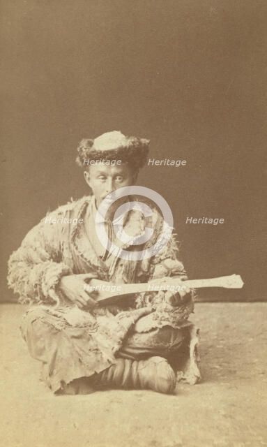 Kazakh man, a musician with a dombra, seated, between 1870 and 1886. Creator: Unknown.