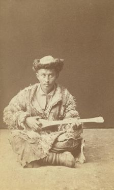 Kazakh man, a musician with a dombra, seated, between 1870 and 1886. Creator: Unknown