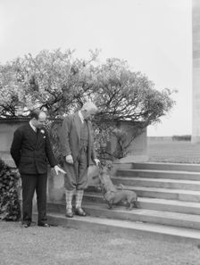 Kahn, Otto H., Mr., and unidentified man, with dog, standing outdoors, 1928 Creator: Arnold Genthe