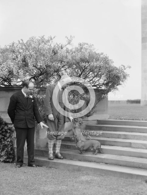Kahn, Otto H., Mr., and unidentified man, with dog, standing outdoors, 1928 Creator: Arnold Genthe.