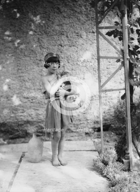 Kanellos child in dance costume holding a cat, 1929 Creator: Arnold Genthe.