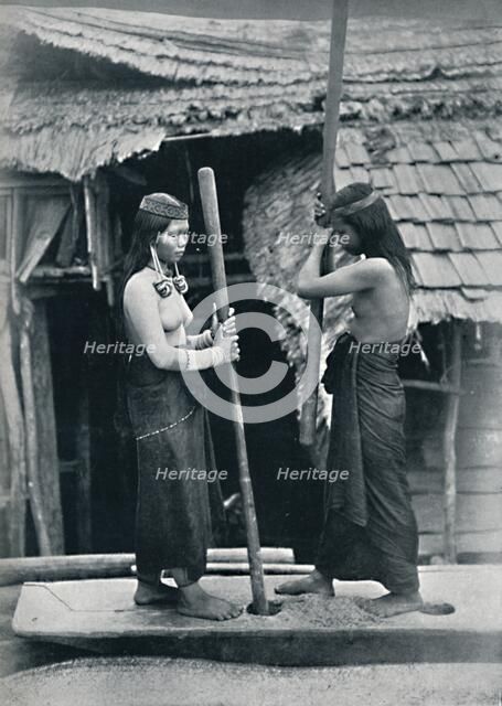 Kenyah women pounding rice, Sarawak, 1902. Artist: Dr Charles Hose.
