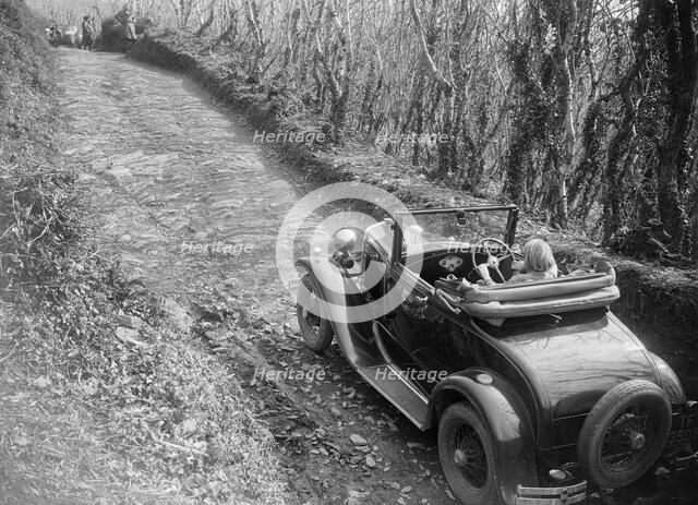Kitty Brunell driving a 1930 Ford Model A 2-seater, 1931. Artist: Bill Brunell.
