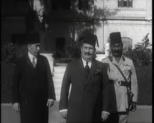 King Faud I Accompanied by One Male Civilian and One Male Soldier Walking Down Steps, 1924. Creator: British Pathe Ltd