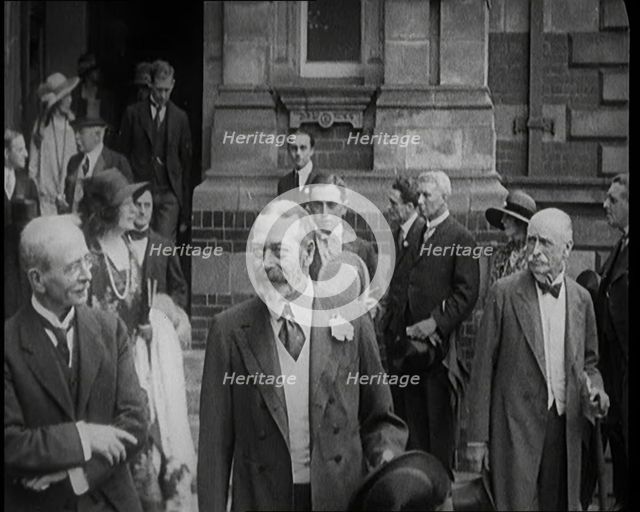 King George V Accompanied by a Group of Officials Emerging from a Building , 1924. Creator: British Pathe Ltd.