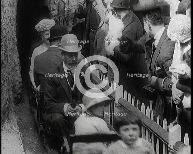 King George V and Queen Mary of the United Kingdom Sit in a Model Train As It Passes..., 1924. Creator: British Pathe Ltd.