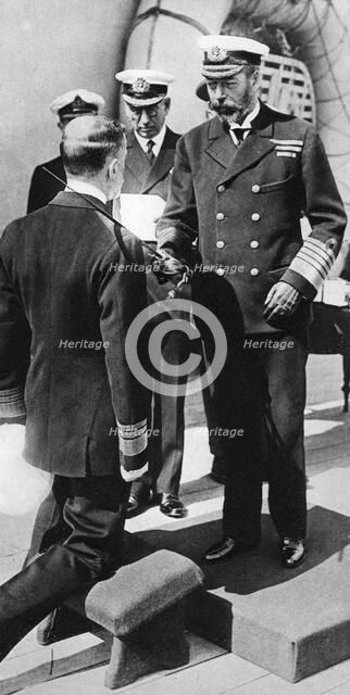 King George V knights Vice-Admiral Pakenham aboard HMS Princess Royal, c1930s. Artist: Unknown