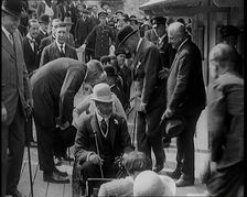 King George V of the United Kingdom Sitting On a Model Train With a Crowd of People Watching, 1924. Creator: British Pathe Ltd